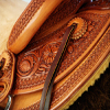 Half Breed Vaquero Wade Saddle by Keith Valley Specs: Wade tree by Rick Reed 15 & 1/2 inch seat, Gullet - 7 & 1/2H X 6 & 1/4W X 4, 93 Degree Bars, Horn - 3 & 5/8ths high X 4 & 1/2 Guatelajara, Cantle - 4&1/2 inches high X 12&1/2 inches wide, Cheyenne Roll - 1 & 3/4 inches, 7/8ths flat plate riggin. Sporting Keith's Vaquero Border with Sheridan Floral tooling within, Stainless Steel Hardware - by Harwood, 4 inch Monel Stirrups, Santa Barbara twisted for easy handling, Vaquero outside stirrup leathers, 100% handmade Mohair Roper Cinch, Hand cut 7 foot latigos for both sides. Made for a special order - **SOLD** but we take orders.